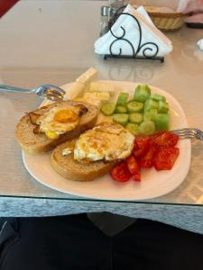 a plate of breakfast food with eggs and vegetables at Treeolives in Shkodër +11 photos