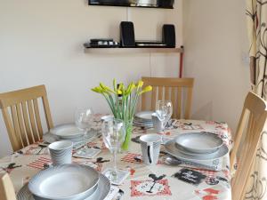 a dining room table with plates and glasses on it at Kingfisher Cottage - 25114 in Flamborough