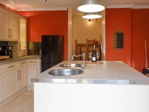 a kitchen with a sink and a black refrigerator at Burnbrae Cottage in Bridgend of Lintrathen