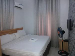 a bedroom with a bed with a fan next to a window at 2 Bedroom apartment in Ikeja with free wifi in Ijaiye