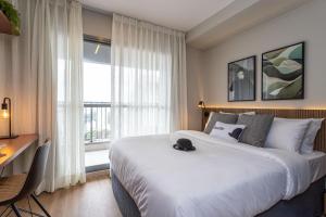 une chambre d'hôtel avec un lit, un bureau et une fenêtre dans l'établissement Charlie For You Vila Mariana, à São Paulo
