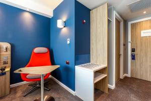 a room with a red chair and a desk at Holiday Inn Express London-Hammersmith by IHG in London +40 photos