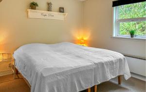 a bedroom with a bed with a white blanket at Awesome Home In Farsø With Sauna in Farsø