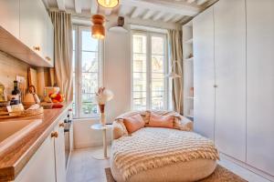a cozy ottoman in a kitchen with a window at Le Saint-Sauveur - Chaleureux 2 pièces - Vidéoprojecteur in Caen