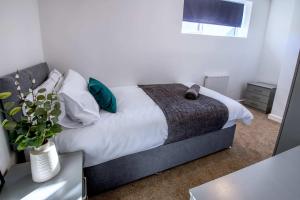 a bedroom with a bed and a vase with a plant at NEW Contractor 5-Bed 3-Bath Central Redcar in Redcar