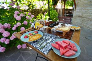 a table with two plates of food and watermelon at Palorto Hotel in Gjirokastër