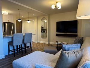 a living room with a couch and a tv and a kitchen at Saint John's Resort in Plymouth