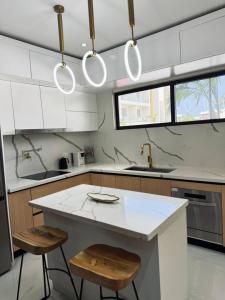 a kitchen with a white counter and two stools at The Nest At Paradisiac in Ocho Rios +18 photos