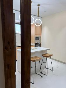 a kitchen with a white counter and two stools at The Nest At Paradisiac in Ocho Rios