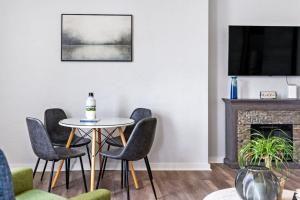 a living room with a table and chairs and a fireplace at Hot Tub Comfort in Walkable Lawrenceville in Lawrenceville
