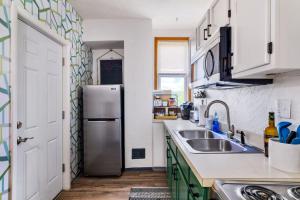 a kitchen with a refrigerator and a sink at Hot Tub Comfort in Walkable Lawrenceville in Lawrenceville