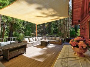 a patio with couches and a large umbrella on a deck at The Bungalow on the stream in Sundance
