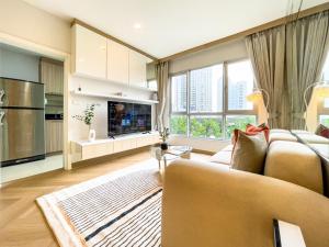 a living room with a couch and a large window at Elegant Stay near IconSiam l High-speed WiFi l BTS Wongwian Yai in Godown