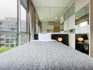 a bedroom with a large bed and large windows at Elegant Stay near IconSiam l High-speed WiFi l BTS Wongwian Yai in Godown +28 photos