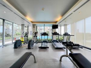 a gym with treadmills and ellipticals in a room with windows at Elegant Stay near IconSiam l High-speed WiFi l BTS Wongwian Yai in Godown