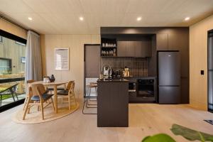 a kitchen and dining room with a table and a refrigerator at Villa XV Stylish and Contemporary Escape in Queenstown Airport