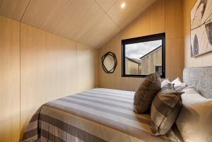 a bed in a small room with a window at Villa XV Stylish and Contemporary Escape in Queenstown Airport