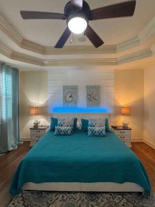 1 dormitorio con cama verde y ventilador de techo en Luxurious Beachfront Home with Hot Tub Fenced Yard Bikes Fire Pit, en Marineland