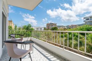 a balcony with a table and chairs and a view at Ochra - Stylish 2-BR Apt & Balcony in Batroun in Ed Daourâ