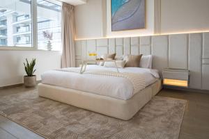 une chambre avec un grand lit blanc dans une pièce dans l'établissement Yas Island Resort Beach Access Luxury in Mayan 1 BEDROOM, à Yas Island 52 autres photos