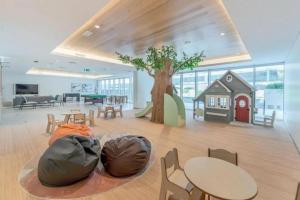 une grande salle avec des tables et une maison de jeu dans l'établissement Yas Island Resort Beach Access Luxury in Mayan 1 BEDROOM, à Yas Island