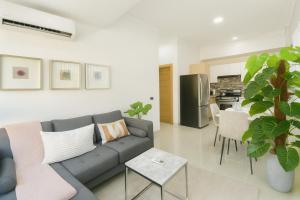 a living room with a couch and a kitchen at Cozy, City Center Condo in Santo Domingo