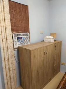 a room with a heater and a wooden cabinet at AVA Cabanatuan Transient House in Bantug