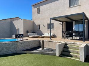Un patio trasero con piscina y una casa. en Charmante maison avec petite piscine et jardin, en Port-la-Nouvelle