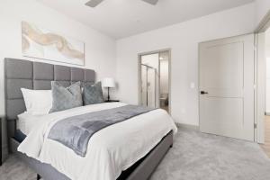 a white bedroom with a large bed and a closet at The Icon 5 Min From Downtown in Wilders Grove +41 photos
