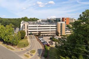 an office building with cars parked in a parking lot at The Icon 5 Min From Downtown in Wilders Grove