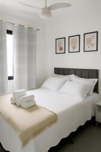 a white bedroom with a large white bed with two towels at Bela Vista São Paulo "Apto moderno, confortável e proximo a varios pontos turistico" in Sao Paulo