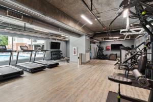 een sportschool met loopbanden en apparaten in een kamer bij Unique Living 5 Min From Downtown in Wilders Grove