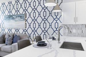 een keuken met een bank en een tafel met een wijnglas bij Unique Living 5 Min From Downtown in Wilders Grove +31 foto's