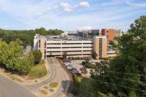 een kantoorgebouw met auto's geparkeerd op een parkeerplaats bij Unique Living 5 Min From Downtown in Wilders Grove