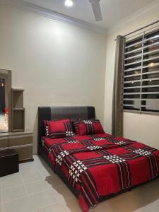 Un dormitorio con una cama roja con almohadas rojas. en Mommy Homestay Kuala Terengganu private pool, en Kuala Terengganu 5 fotos más