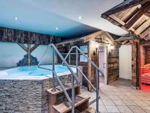 a hot tub in a room with a stone wall at Mercure Sighisoara Binderbubi Hotel & Spa in Sighişoara