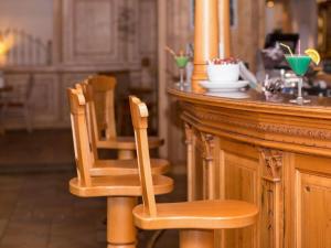 a wooden bar with two chairs at a counter at Mercure Sighisoara Binderbubi Hotel & Spa in Sighişoara +153 photos
