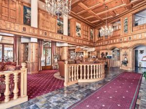 een grote lobby met houten wanden en een kroonluchter bij Mercure Sighisoara Binderbubi Hotel & Spa in Sighişoara