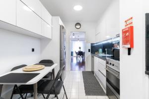 a kitchen with white cabinets and a table and chairs at Carmo Lookout in Câmara de Lobos