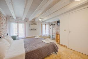 a bedroom with a bed and a brick wall at Balastro Design Rooms - Venice City Center in Venice