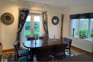a dining room with a table and chairs and a window at 2-Bedroom Cottage with 2 Ensuites - Sleeps 6 Wifi in Rye