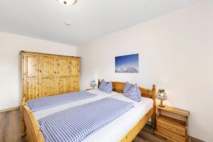 ein Schlafzimmer mit einem Bett und einem Holzschrank in der Unterkunft Fewo Brünnstein - Nr 44 Pool, Sauna in Oberaudorf