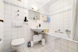 ein weißes Badezimmer mit Toilette und Waschbecken in der Unterkunft Fewo Brünnstein - Nr 44 Pool, Sauna in Oberaudorf + 12 Fotos