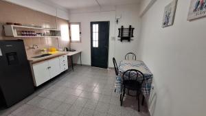 Una cocina con mesa y sillas y un refrigerador. en Departamentos Melina, en San Miguel de Tucumán