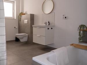 Un baño con lavabo, inodoro y espejo. en 217 Schortens, en Schortens 16 fotos más