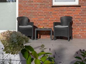 three wicker chairs and a table on a patio at 217 Schortens in Schortens +16 photos