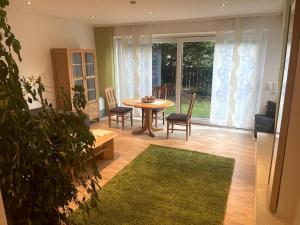 a living room with a table and chairs and a large window at Traumhafte Gartenwohnung in Pfaffenhofen an der Ilm
