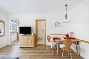 オーバーアウドルフにあるFewo Brünnstein - Nr 35 Romantikのテーブルと椅子のあるキッチンとダイニングルーム