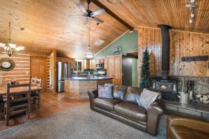 a living room with a leather couch and a stove at Stapp Mountain Retreat in South Fork, CO in South Fork