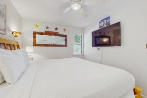 a white bedroom with a bed and a tv at Beachwood Villas 7C in Seagrove Beach +21 photos